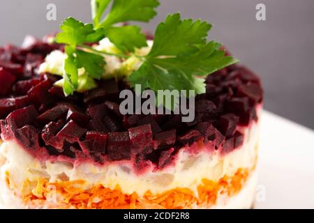 Traditional Russian herring salad with beetroot and carrots on black background Stock Photo