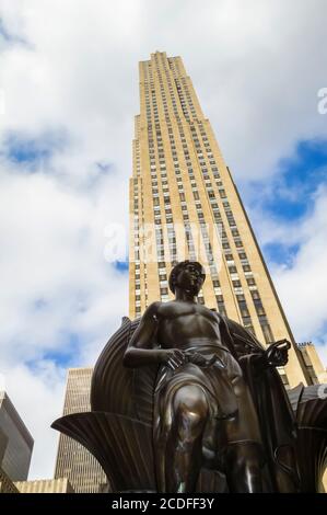 Statue in front of the tall skyscraper 30 Rockefeller Plaza at the Rockefeller Center, Midtown Manhattan, New York City, New York, USA Stock Photo