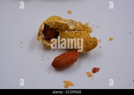 Natural peanuts in their own peel, which is opened in various ways. Opened shells with peanut nuts are located on a white background. Stock Photo