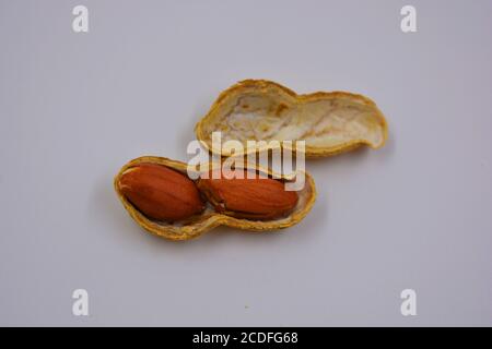 Natural peanuts in their own peel, which is opened in various ways. Opened shells with peanut nuts are located on a white background. Stock Photo