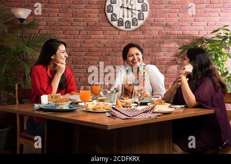 Indian friends eating or dining in restaurant. Asian people in face for get-together, reunion or celebrating party. Coffee Shop Celebration Friendship Stock Photo