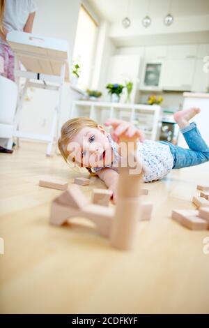 Girl builds a house from wooden blocks at home Stock Photo