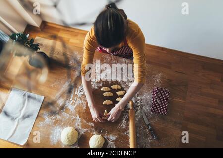 High angle view of woman making rolls on kitchen table Stock Photo