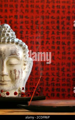 Buddha head and incense Stock Photo