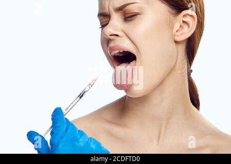 Woman in blue gloves with syringe in hand with botox injection treatment against wrinkles Stock Photo