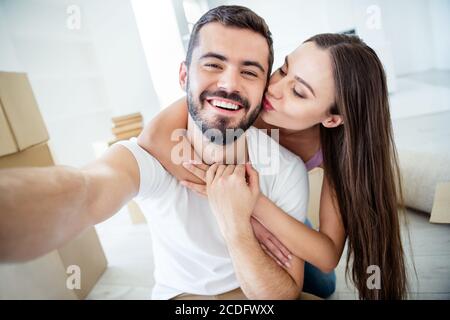 Self-portrait of his he her she nice attractive cheerful cheery dreamy married spouses embracing kissing rent loan purchase accommodation at flat Stock Photo