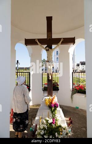 Pilgrim praying by a statue of Jesus Christ at Aglona Basilica on the Celebration of the Assumption of Mary (15 August) in the Latgale region of Latvi Stock Photo
