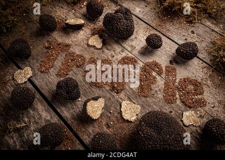 Black truffles on the old wooden table with truffle text Stock Photo