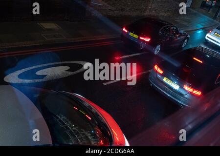 Seen from a London bus on a rainy night in the West End, cars queue in traffic at the edge of the Congestion Charge zone whose times of operation have temporarily changed to seven days a week during the Coronavirus pandemic, on 27th August 2020, in London, England. Stock Photo