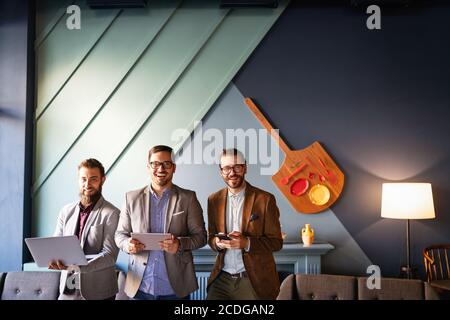 Group of confident happy business people holding digital devices Stock Photo