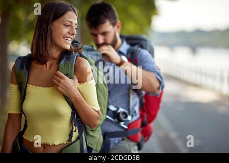 smiling tourists enjoying on vacation, young couple having fun walking on city street Stock Photo