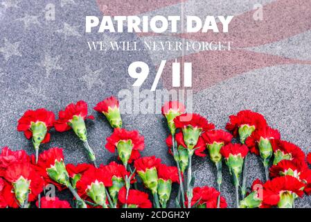 Carnations on the memorial with the American flag and the phrase patriots ' Day. September 11. We will never forget. Anniversary of the attack. Stock Photo