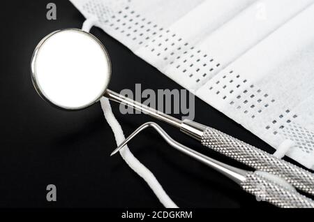 Set of metal Dentist's medical equipment tools on black backgound. Stock Photo