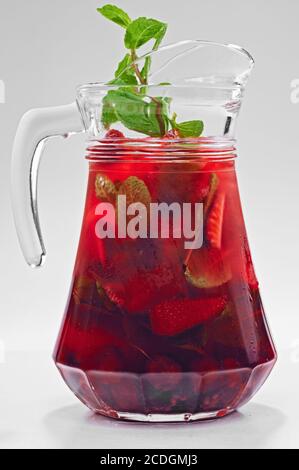 Refreshing cold strawberry drink with ice, raspberry and mint leaves in glass jar isolated on white Stock Photo