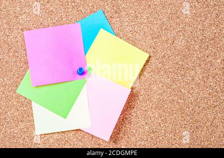 Blank sticky notes pinned on cork memo board. Stock Photo