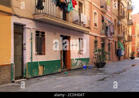 A scene of a narrow pedestrian street in La Barceloneta, a neighborhood in Barcelona, Spain. Build in the 18th century it is still inhabited by many f Stock Photo