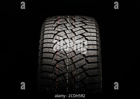 winter studded tire, front view. close-up on a black background Stock Photo