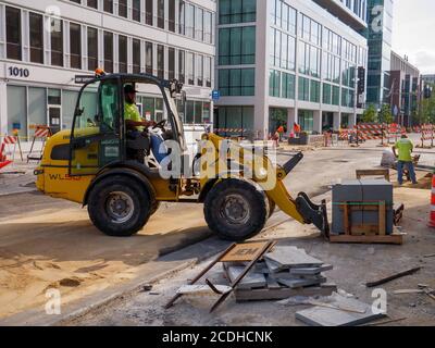 Loader with fork lift attachment lifting pavement blocks. Lake Street Reconstruction Project, Oak Park, Illinois. Stock Photo