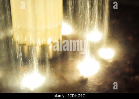 close-up of a jet of water fountain at night illuminated by lamps Stock Photo