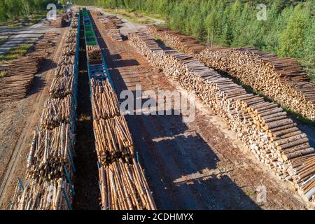 Aerial view of a railroad yard with log piles and train wagons loaded with timber for transport at Summer , Finland Stock Photo