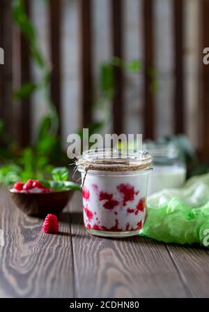 Raspberry smoothie, milkshake in a glass jar on a dark wooden background. Yogurt cocktail. Natural summer detox drink Stock Photo