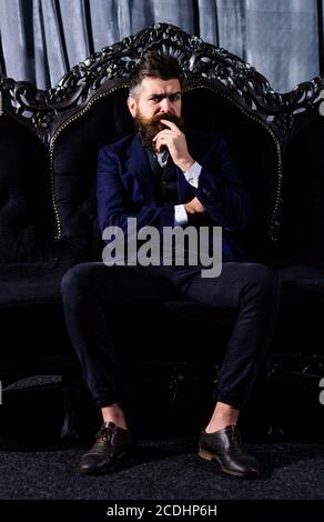 Serene unshaven mature man sitting on sofa. Relax and rich concept Stock Photo