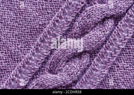 Openwork pattern knitted with needles from pink wool yarn. Stock Photo