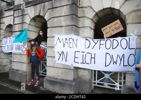 Menai Bridge, Anglesey, 28 August 2020. Extinction Rebellion youth protestors face the bank holiday traffic heading into Anglesey with banners highlighting climate change and calling for action to protect their future Credit: Denise Laura Baker/Alamy Live News Stock Photo