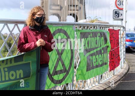 Menai Bridge, Anglesey, 28 August 2020. Extinction Rebellion youth protestors face the bank holiday traffic heading into Anglesey with banners highlighting climate change and calling for action to protect their future Credit: Denise Laura Baker/Alamy Live News Stock Photo