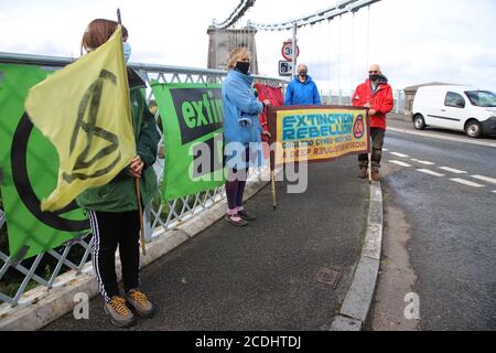 Menai Bridge, Anglesey, 28 August 2020. Extinction Rebellion youth protestors face the bank holiday traffic heading into Anglesey with banners highlighting climate change and calling for action to protect their future Credit: Denise Laura Baker/Alamy Live News Stock Photo