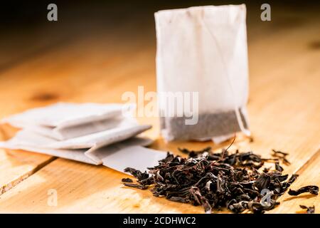 Tea bag on wooden background. Tea bag and tea leaves on a wooden background. Stock Photo