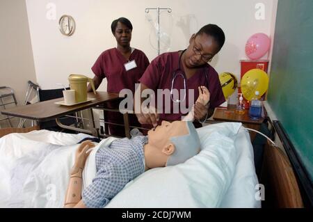 Pine Bluff, Arkansas:  October 16, 2006: Community college students practice nursing care techniques with a dummy simulating an elderly patient while taking a hands-on class on nursing home care. ©Bob Daemmrich Stock Photo