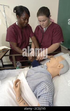 Pine Bluff, Arkansas:  October 16, 2006: Community college students practice nursing care techniques with a dummy simulating an elderly patient while taking a hands-on class on nursing home care. ©Bob Daemmrich Stock Photo