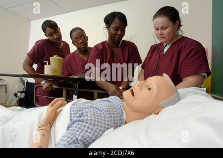 Pine Bluff, Arkansas:  October 16, 2006: Community college students practice nursing care techniques with a dummy simulating an elderly patient while taking a hands-on class on nursing home care. ©Bob Daemmrich Stock Photo