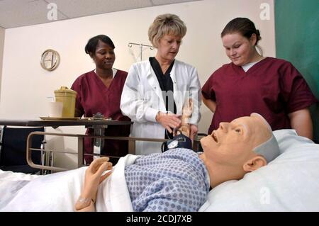 Pine Bluff, Arkansas:  October 16, 2006: Community college students practice nursing care techniques with a dummy simulating an elderly patient while taking a hands-on class on nursing home care. ©Bob Daemmrich Stock Photo