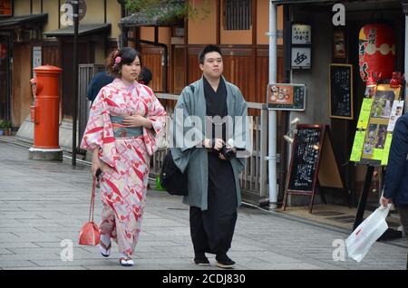 Traditionally dressed couple walking the streets of Gion, old town of Kyoto. Stock Photo