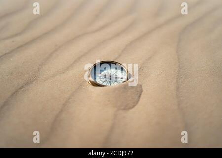 ancient compass on desert sand Stock Photo