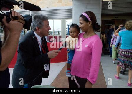 Austin, TX June 26, 2007: African-American woman interviewed by a local TV reporter at the grand opening of the $200-million Dell Children's Medical Center in Austin, a 500,000 square-foot state-of-the-art hospital with 24 intensive care beds and 170 patient rooms. ©Bob Daemmrich Stock Photo