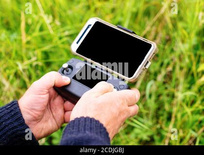 a man's hands holding remote control  for launching a drone on a meadow Stock Photo
