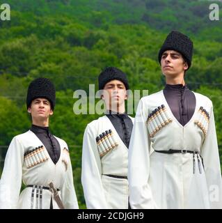 Adygea, RUSSIA - JULY 25 2015: Young guys in Adyghe national costumes dancing traditional dance at an ethnofestival in the Foothills of Caucasus in Ad Stock Photo