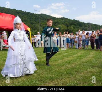 DAKHOVSKY, RUSSIA - JULY 25 2015: The boy and the girl in beautiful national suits dance traditional Adyghe dance. The Festival 'Lago-Naki: Kunatskaya Stock Photo