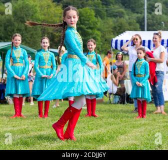 DAKHOVSKY, RUSSIA - JULY 25 2015: The girl in beautiful national Adyghe dresses dances traditional dance. The Festival 'Lago-Naki: Kunatskaya' was hel Stock Photo