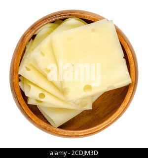 Emmental cheese slices in a wooden bowl. Folded slices of Emmenthal or Emmentaler. Yellow Swiss cheese with holes, medium-hard, with savory mild taste. Stock Photo