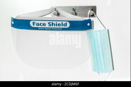 PPE supplies face shield direct splash protection and mask hanging on hooks. New clean corona virus protective equipment ready to use for coronavirus Stock Photo