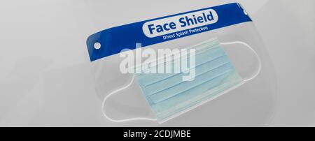 PPE for covid and corona virus. Medical mask and face shield protective equipment for healthcare workers and business. Panoramic banner crop of face Stock Photo