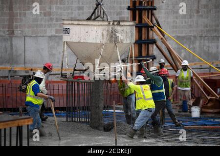 Austin, TX USA August 22, 2020: Experienced concrete crew conducts a night pour on the top floor of a high-rise parking garage in downtown Austin. Major construction projects continue unabated during the coronavirus shutdowns in Texas. Stock Photo