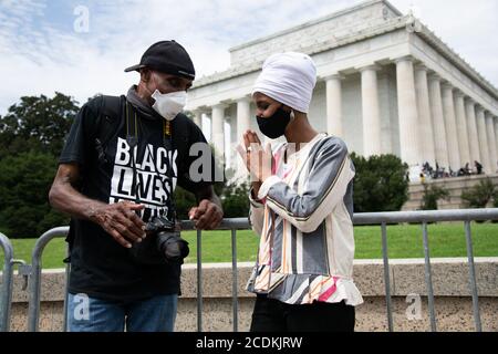 Representative Ilhan Omar (D-MN) speaks with a protester in front of the Lincoln Memorial on the National Mall during the civil rights march organized by Al Sharpton calling attention to systemic racism and police violence after the May police killing of George Floyd in Minnesota, in Washington, DC, on August 28, 2020, amid the coronavirus pandemic. The night before The Commitment March: Get Your Knee Off Our Necks, protests consumed the blocks surrounding the White House, as President Trump gave his presidential nomination acceptance speech with sounds from noisy demonstrations in the backg Stock Photo