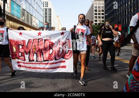 Washington, DC, USA, 28 August, 2020.  Pictured: Protesters from The Palm Collective carry their Demand DC banner at the head of a protest march. Local anti-racism social justice organizations gathered at the Human Rights Campaign headquarters to march as a single group to the March on Washington.  Credit: Allison C Bailey/Alamy Credit: Allison Bailey/Alamy Live News Stock Photo