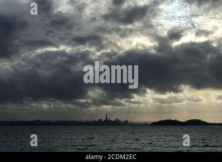 Dramatic evening sky above the Bay of Maori with skyline of Auckland in the background., New Zealand, Northern Island, Auckland Stock Photo