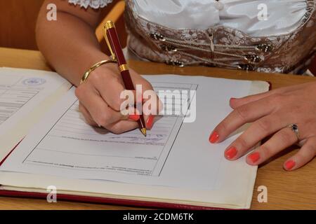 Woman in costume signs document